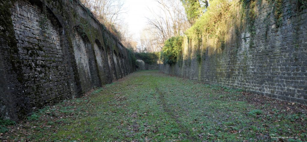 Fossés du Fort de Bron montrant sur les cotés le mur d'escarpe et le mur de contrescarpe.
