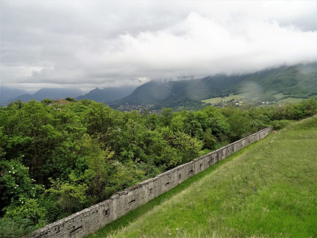 En contre-bas, le chemin de ronde et son mur avec les embrasures (Fort de Comboire)