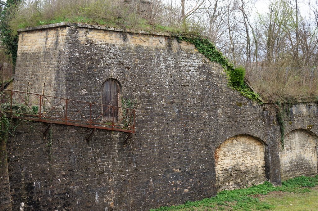 Le ravelin prend appui sur le mur de contrescarpe. Des meurtrières font face au chemin. Une passerelle en façade permet l’accès à la porte  d'entrée du ravelin. Au premier plan le fossé. 